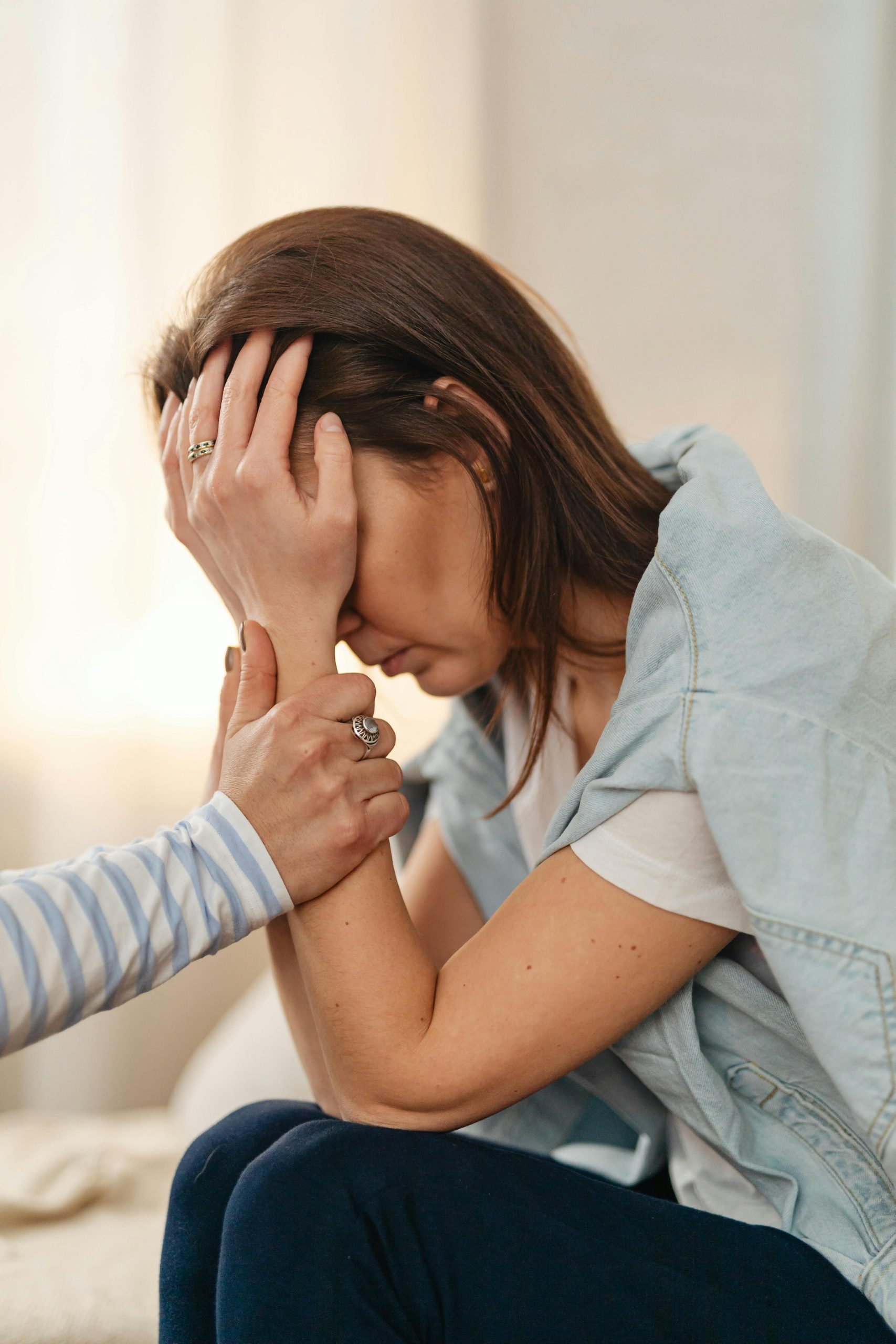 A woman receiving emotional support indoors. Comfort and empathy depicted.